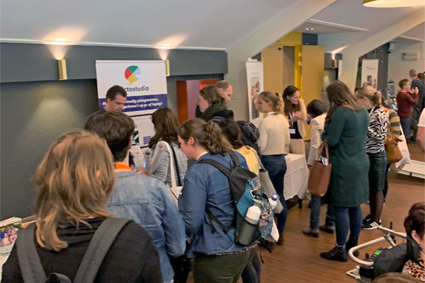 Foto bezoekers van het congres bij de stand van Pictostudio.